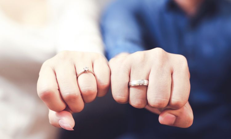 The couple has worn rings in their fingers.